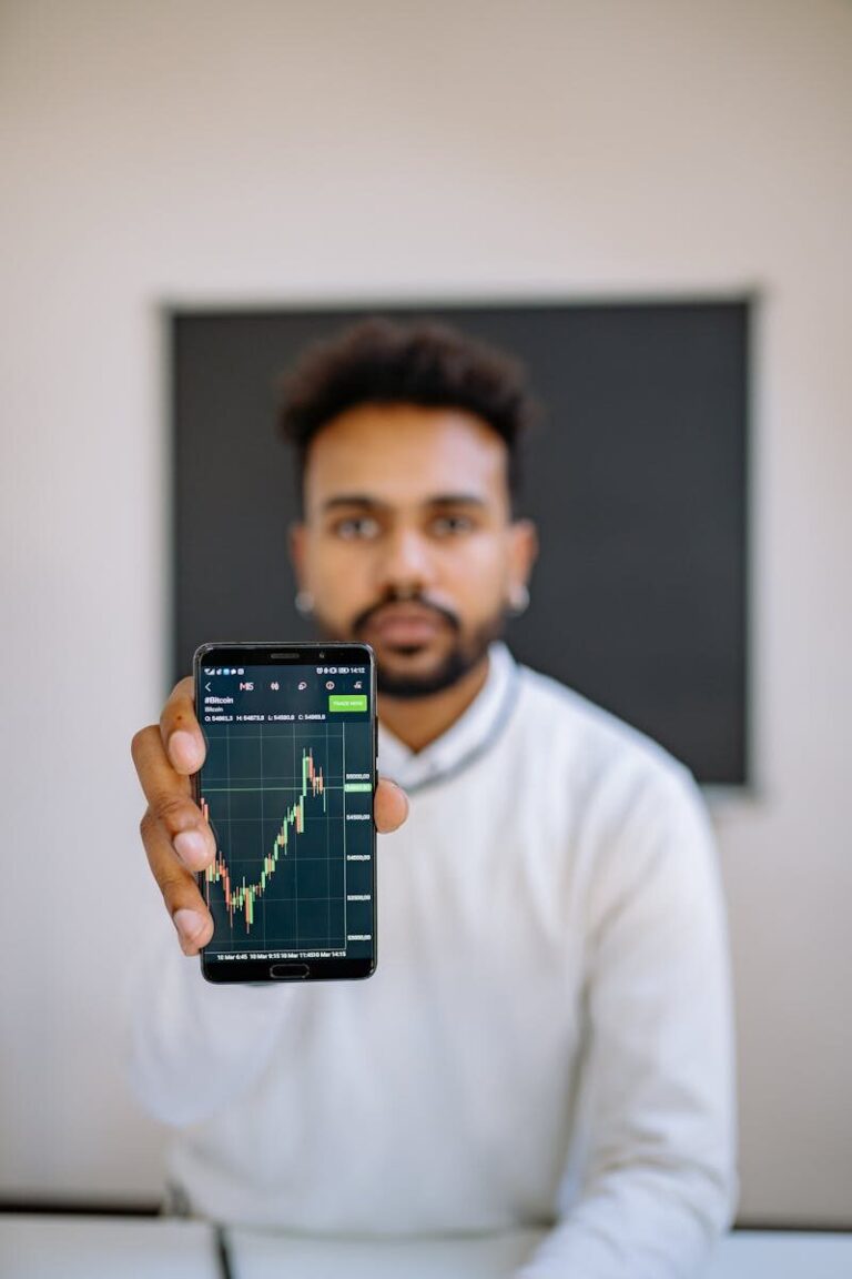 Man holding smartphone with stock market chart, focusing on financial growth.